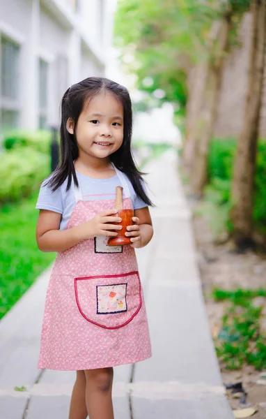 Portret małej dziewczynki w fartuch z zaprawą w ogrodzie — Zdjęcie stockowe