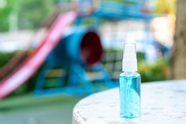 Spray bottle of alcohol for cleaning to prevent the corona virus, Covid-19 with playground background