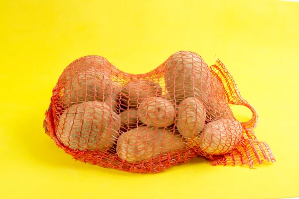 黄色背景的一袋土豆 免版税图库图片