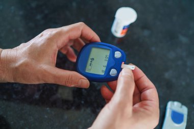 Tıp, Diyabet, Glisemi, Sağlık ve İnsan Konsepti - parmaklarda karyola kullanarak kan şekeri seviyesini Glikoz ölçer ile ölçmeye çalışan kadınlara yakın çekim