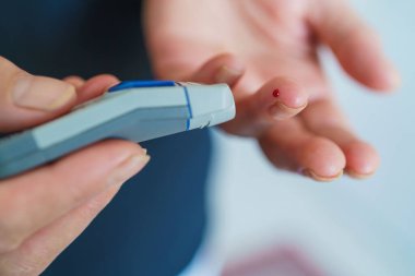 Tıp, Diyabet, Glisemi, Sağlık ve İnsan Konsepti - parmaklarda karyola kullanarak kan şekeri seviyesini Glikoz ölçer ile ölçmeye çalışan kadınlara yakın çekim