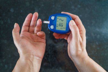 Tıp, Diyabet, Glisemi, Sağlık ve İnsan Konsepti - parmaklarda karyola kullanarak kan şekeri seviyesini Glikoz ölçer ile ölçmeye çalışan kadınlara yakın çekim