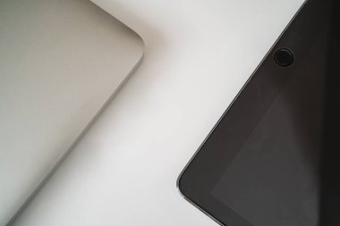 Düz kompozisyonda dizüstü bilgisayar ve tablet beyaz zemin üzerinde yatıyordu. Merkez Ofis
