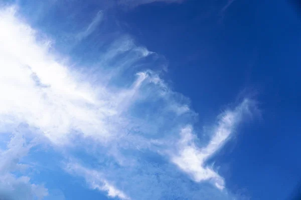 Beautiful white and gray clouds against the blue sky. Summer and autumn day with a view from the airplane to the atmosphere. Stock Photo for design