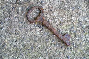 Bir antika paslı metal anahtar beton zemin üzerine. Gizem tarafından korunan romantik bir sır. Stok fotoğraf.