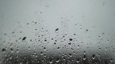 Yeşil ağaç arka planda penceresindeki yağmur damlaları. Bahar fırtına şehir. Stok video