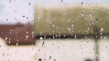 Yeşil ağaç arka planda penceresindeki yağmur damlaları. Bahar fırtına şehir. Stok video