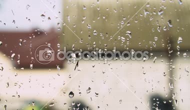 Yeşil ağaç arka planda penceresindeki yağmur damlaları. Bahar fırtına şehir. Stok video