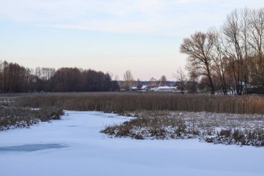 Karlı bir nehir ve gölü olan güzel bir kış manzarası. Noel ve Yeni Yıl teması