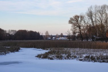 Karlı bir nehir ve gölü olan güzel bir kış manzarası. Noel ve Yeni Yıl teması