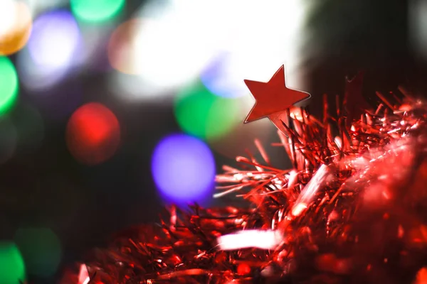 Bela estrela vermelha de Natal em um fundo de guirlandas de bokeh. Natal tema design — Fotografia de Stock