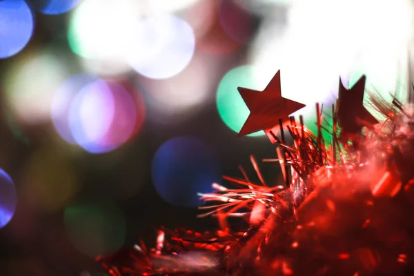 Bela estrela vermelha de Natal em um fundo de guirlandas de bokeh. Natal tema design — Fotografia de Stock