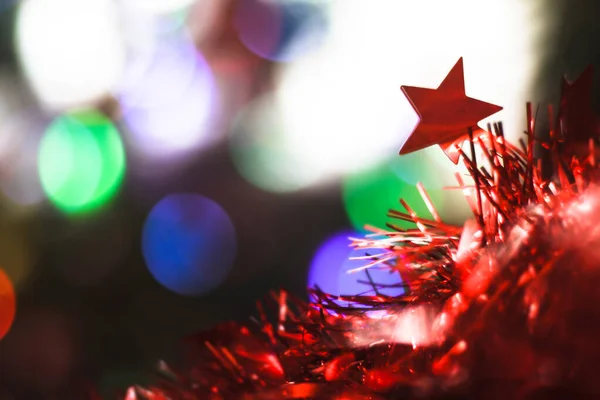 Bela estrela vermelha de Natal em um fundo de guirlandas de bokeh. Natal tema design — Fotografia de Stock