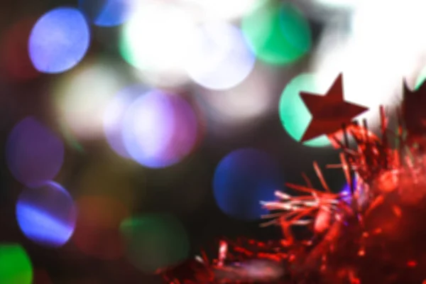 Bela estrela vermelha de Natal em um fundo de guirlandas de bokeh. Natal tema design — Fotografia de Stock