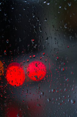 Yağmurlu bir caddeye bakan pencere. Yol manzaralı kasvetli bir akşam havası. Arabalardan camlara ve bokeh 'lere düşer. Tasarım için stok arkaplanı