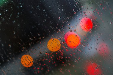 Yağmurlu bir caddeye bakan pencere. Yol manzaralı kasvetli bir akşam havası. Arabalardan camlara ve bokeh 'lere düşer. Tasarım için stok arkaplanı