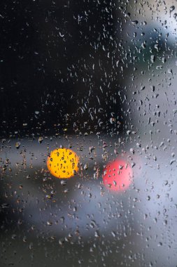 Yağmurlu bir caddeye bakan pencere. Yol manzaralı kasvetli bir akşam havası. Arabalardan camlara ve bokeh 'lere düşer. Tasarım için stok arkaplanı