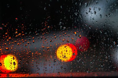 Yağmurlu bir caddeye bakan pencere. Yol manzaralı kasvetli bir akşam havası. Arabalardan camlara ve bokeh 'lere düşer. Tasarım için stok arkaplanı