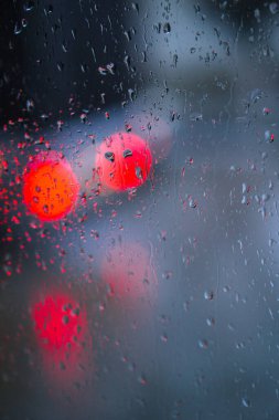 Yağmurlu bir caddeye bakan pencere. Yol manzaralı kasvetli bir akşam havası. Arabalardan camlara ve bokeh 'lere düşer. Tasarım için stok arkaplanı