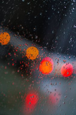 Yağmurlu bir caddeye bakan pencere. Yol manzaralı kasvetli bir akşam havası. Arabalardan camlara ve bokeh 'lere düşer. Tasarım için stok arkaplanı