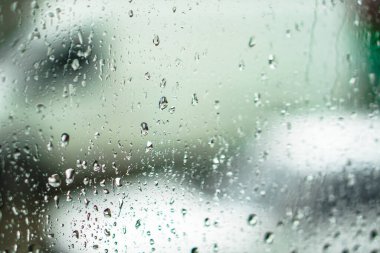 Yağmurlu bir caddeye bakan pencere. Yol manzaralı kasvetli bir akşam havası. Arabalardan camlara ve bokeh 'lere düşer. Tasarım için stok arkaplanı
