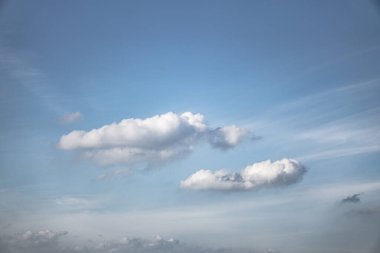 Mavi arka planda güzel bir gökyüzü ve bir uçak penceresi. Çeşitli şekillerde beyaz bulutlar. Tasarım için stok arkaplanı