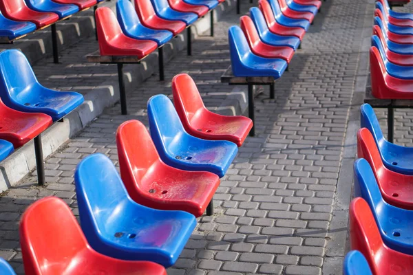 スタジアムの多色の座席が雨の中ぬれた 路上の汚いスツール — ストック写真