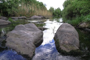 Yazın dağlık bölgede güzel bir nehir. Tepelerin arkasındaki ekolojik olarak temiz bir park bölgesinde. Baharda güzel bir manzara. Tasarım için stok fotoğrafı