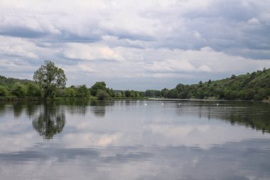 Yazın dağlık bölgede güzel bir nehir. Tepelerin arkasındaki ekolojik olarak temiz bir park bölgesinde. Baharda güzel bir manzara. Tasarım için stok fotoğrafı