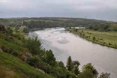 Turistlerle dolu hızlı hareket eden bir teknesi olan nehir manzaralı bir yer. Balıkçılar avlanmak için gemiye biniyor. Güzel, güzel bir manzara. Stok fotoğrafı