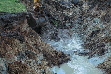 Bir kazıcı ev inşa etmek için büyük bir çukur kazar. Bir traktör zaten su kazanan büyük bir göl kazıyor. Tasarım için stok arkaplanı