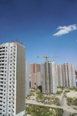 İnşaat sırasında çok aşamalı inşaat ve sarı bir vinç. Tasarım için endüstriyel arkaplan.