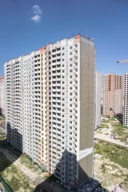Mavi gökyüzünün arka planında büyük bir inşaat alanı. Brick, apartman dairesi. Tasarım için sanayi teması