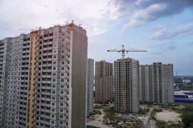 İnşaat sırasında çok aşamalı inşaat ve sarı bir vinç. Tasarım için endüstriyel arkaplan.