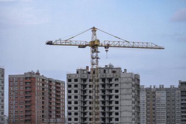 İnşaat sırasında çok aşamalı inşaat ve sarı bir vinç. Tasarım için endüstriyel arkaplan.