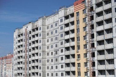 Mavi gökyüzünün arka planında büyük bir inşaat alanı. Brick, apartman dairesi. Tasarım için sanayi teması
