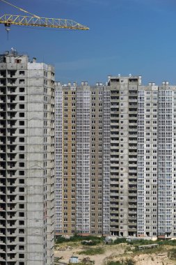 İnşaat sırasında çok aşamalı inşaat ve sarı bir vinç. Tasarım için endüstriyel arkaplan.