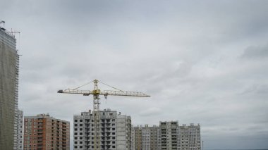 İnşaat sırasında çok aşamalı inşaat ve sarı bir vinç. Tasarım için endüstriyel arkaplan.