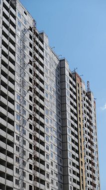 Mavi gökyüzünün arka planında büyük bir inşaat alanı. Brick, apartman dairesi. Tasarım için sanayi teması