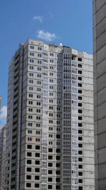 Mavi gökyüzünün arka planında büyük bir inşaat alanı. Brick, apartman dairesi. Tasarım için sanayi teması