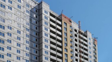Mavi gökyüzünün arka planında büyük bir inşaat alanı. Brick, apartman dairesi. Tasarım için sanayi teması