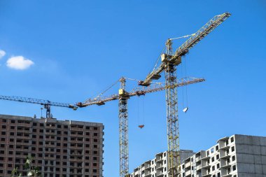 İnşaat sırasında çok aşamalı inşaat ve sarı bir vinç. Tasarım için endüstriyel arkaplan.