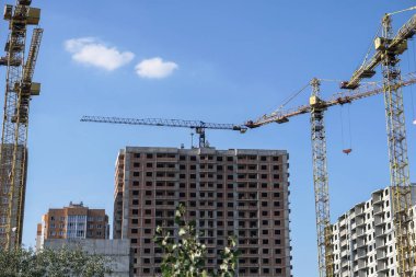 İnşaat sırasında çok aşamalı inşaat ve sarı bir vinç. Tasarım için endüstriyel arkaplan.