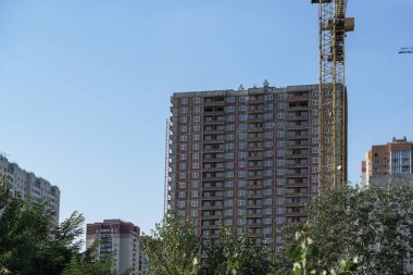 İnşaat sırasında çok aşamalı inşaat ve sarı bir vinç. Tasarım için endüstriyel arkaplan.