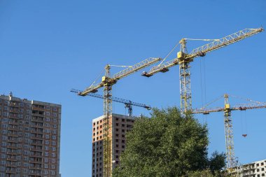 İnşaat sırasında çok aşamalı inşaat ve sarı bir vinç. Tasarım için endüstriyel arkaplan.