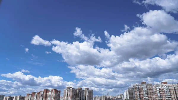 Apartment buildings on a background of beautiful clouds. High-rise buildings are built with panel construction in which people live. Stock photo background