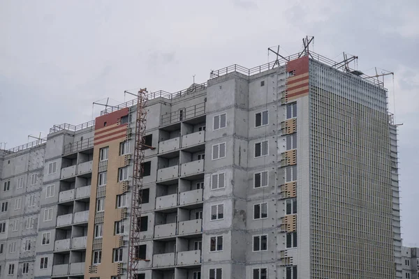 Large construction site on a background of blue sky. Brick, panel apartment building. Industrial theme for design