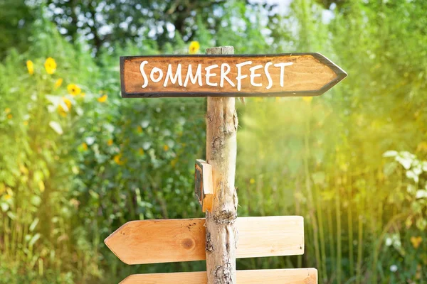 Wooden direction sign with the German word Summerparty (Sommerfest)