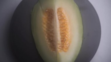 Derisi bozulmamış ve tohumlarla dolu bir karpuz dilimi üst açıdan çekiliyor. Çekim, doğal dokuyu, tazeliği ve tropikal meyvelerin detaylarını vurguluyor. 4k 