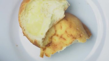 İzole edilmiş beyaz arka planda dönen iki peynir aromalı ekmek, üst manzara. Atış, fırın ürünleri, tuzlu abur cuburlar ve taze pişmiş yiyecekleri en az düzeyde ön plana çıkarıyor. Yemek için mükemmel. 4K